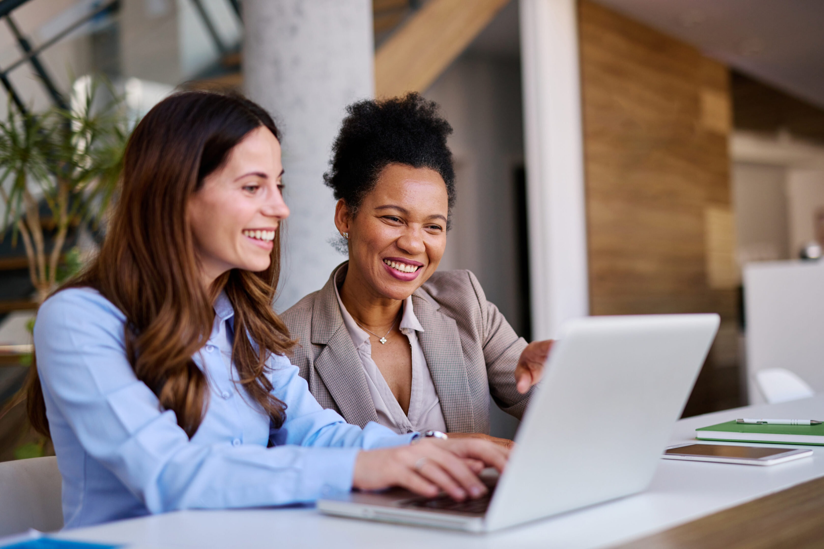 Two women smiling at a laptop